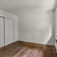 A room with a white wall and a wooden floor.